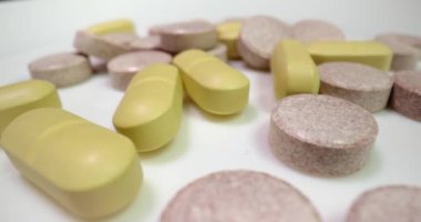 Beyaz yüzeyde dönen ilaç ya da uyuşturucu hapları, çeşitli yığınlar