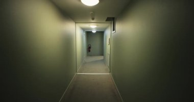 Dairelerin kapıları ve ışıkları yanan düz bir koridor.