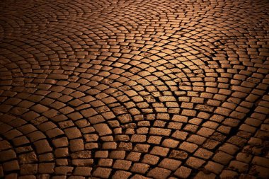Gecenin karanlığında eski taşlardan yapılmış karanlık kaldırım, kaldırım taşları.