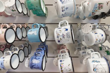 Ivalo, Finlandiya - 22 Şubat 2022: Moomins temalı kupalar havaalanı hediyelik eşya dükkanında satılıyor. Fin çocuk kitapları ve çizgi filmlerinin popüler karakterleri, Moomin ailesinin üyeleri.