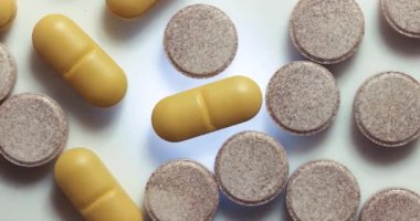 Parlak şeffaf bir yüzey üzerinde dönen ilaç ya da ilaç hapları