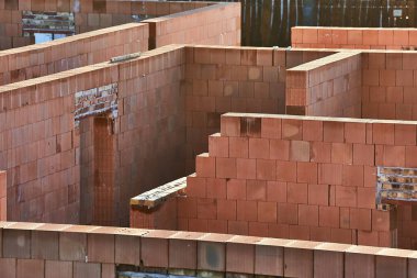 Çıplak tuğla duvarlı inşaat halinde bir ev.