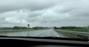 Yağmurda araba sürmek, iç manzara, yağmurlu ve kasvetli havada silecekleri çalıştırmak.