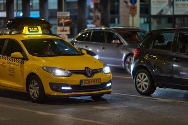 Budapeşte, Macaristan - 24 Mayıs 2024: Budapeşte 'de gece şehir merkezi trafiği, taksiyle önde giden arabalar