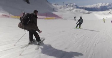 Alplerde kayak yaparken, kayakçı hızla inerken, dinamik çekim yaparken, sakallı adam deli gibi giderken.