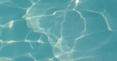 Bir havuzun dalgalı su yüzeyi dalgaları, arka plan deseni, güneş ışığı yansıması, parlak yaz