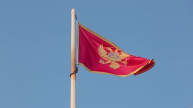 Karadağ bayrağı, 120 fps 'ten yavaş çekimde bulutlu gökyüzü Karadağ' a doğru dalgalanıyor