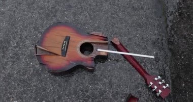 Karlı yağmurda yere düşen kırık bir gitar. Öfke, sokak çaldıktan sonra bırakıldı