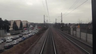 Tren yolculuğu bakış açısı son vagonun arkasından, tren yolu raylarından, yüksek hızda bir istasyondan geçiyor.