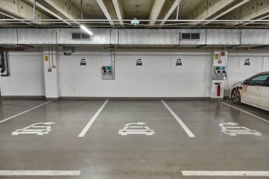Bir yeraltı otoparkındaki elektrikli araba şarj istasyonu, elektrikli araç şarj aleti, uygun yuvaları.