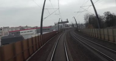 Tren yolculuğu bakış açısı, son vagonun arkasından, şehir merkezindeki bir üstgeçitten hızlı bir yolculuk.
