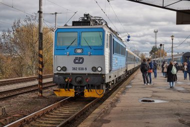 Kutna Hora, Çek Cumhuriyeti - 20 Kasım 2024: Kutna Hora tren istasyonuna gelen yolcu treni CD Skoda 362 sınıfı elektrikli lokomotif ile. İnsanlar platformda bekliyor.