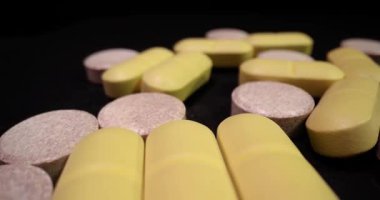 Siyah yüzeyde dönen ilaç hapları, makro çekim