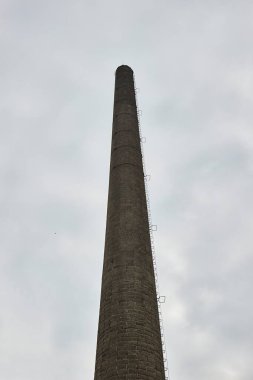 Fabrikanın uzun bacası, kasvetli gökyüzü, terk edilmiş çelik fabrikası, Ostrava demiri.
