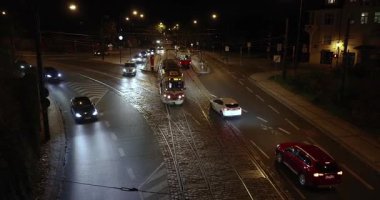 Prag, Çek Cumhuriyeti - 18 Kasım 2024: Prag 'da gece yarısı tramvay ve arabalarla kavşak, karanlıkta farlar