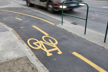 Ana caddede asfalt yüzey ve kaldırımda bisiklet yolu işareti var.