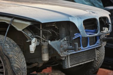 Kırık farları olan bir araba enkazının ön tarafı.