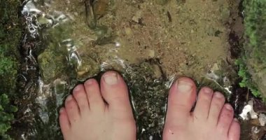 Serin bir dağ deresinde çıplak ayaklar, yaz yürüyüşü için dinlenme, pınarın yanındaki küçük dere.