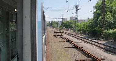 Tren yolculuğu sırasında pencereden dışarı eğilmek, vagon koridorunu görmek için geri gelmek.