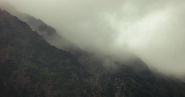 Sisli dağ ormanlarından geçen sis ve bulutlar, destansı manzaralar, keskin kayalık uçurumlar, dramatik kasvetli hava, sinematik doğa