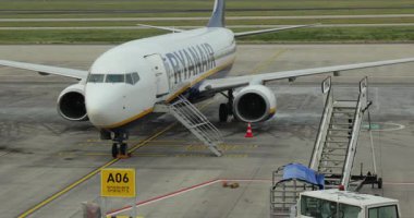 Berlin, Almanya - 21 Ekim 2021: Ryanair Boeing 737 Berlin Brandenburg Havalimanı 'nda yolcu indirmek için uçağın kabin kapısını açan uçuş görevlisi