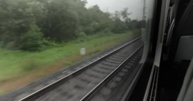 Tren yolculuğu penceresi uzun mesafeli tren yolculuğunda bir virajda, yağmurlu bulutlu bir havada.