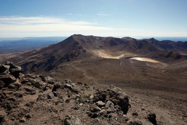 Tongariro Ulusal Parkı, Yeni Zelanda 'daki volkanik manzaralar, dağlarda yürüyüş yolları, çorak kayalık arazi ve göl.