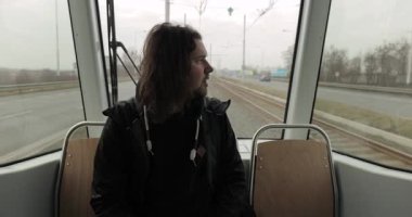 Sabah tramvayda oturan bir adam Ostrava 'da toplu taşıma araçlarıyla işe gidiyor.