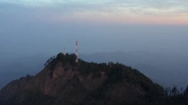 Minca, Kolombiya yakınlarındaki dağın tepesindeki iletişim vericisi kulesi, tropikal dağ manzarası.