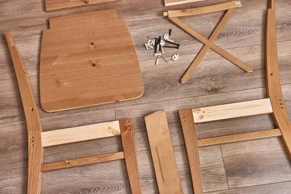 Tahta sandalye monte edilmeye hazır, boks açıldıktan sonra parçalar serilmiş.