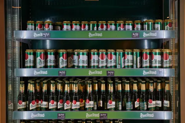 Plzen, Çek Cumhuriyeti - 6 Haziran 2022: Pilsner bira fabrikasının hediye dükkanındaki rafta Pilsner Urquell biraları