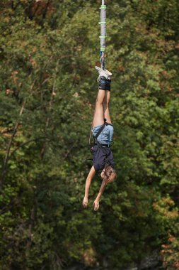 Bungee jumping kızı heyecandan ipte sallanıyor.