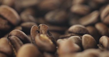 Kahve çekirdekleri arka planda toplanıyor, odaklanma yavaşça geriye kayıyor, yavaş çekim