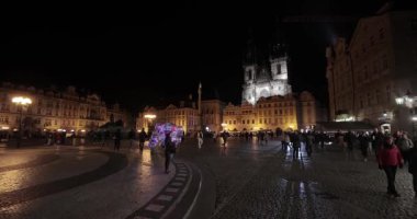 Prag, Çek Cumhuriyeti - 18 Ekim 2023: Prag 'ın tarihi şehir merkezinde Eski Şehir Meydanı' nda gece yürüyüşü Tyn arka planda hüküm sürmeden önce Meryem Ana Kilisesi 'nin gotik kulelerini aydınlattı.