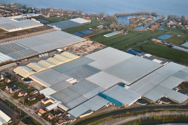 Hollanda 'daki tarlalarda sera yetiştiriciliği, Amsterdam Schiphol Havaalanı' na inmek üzere olan uçan bir uçağın kırsal manzarası.