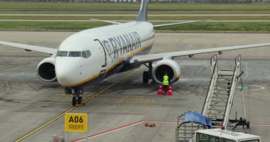 Berlin, Almanya - 21 Ekim 2021: Berlin Brandenburg Havalimanı 'nda Ryanair Boeing 737 uçağı, uçuş görevlisi kabin kapısını açmadan önce merdivenlerde inşa edilmiş küçük bir uçağı serbest bıraktı.