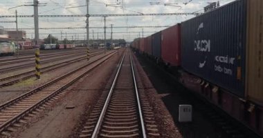 Breclav, Çek Cumhuriyeti - 15 Mayıs 2024: Arkadan korku treni kargo vagonları, endüstriyel parçalardan geçen, önünde Siemens Vectron elektrikli lokomotif motoru olan kargo treni