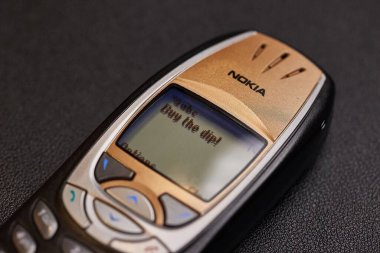Budapeşte, Macaristan - 6 Mart 2025: Kripto para birimi fiyaskosu düşüşü ve ayı pazarı sırasında sos satın alınmasını söyleyen Sms mesajı. Nokia 6310 vintage cep telefonu