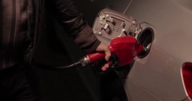 Geceleri benzin istasyonundaki bir arabaya benzin doldurmak.