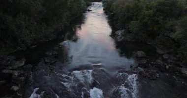 Gün batımında Podgorica 'ya doğru akan nehir, bir köprüden manzara