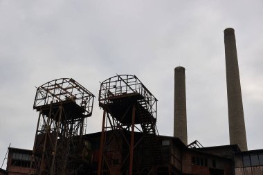 Fabrikanın uzun bacaları ve çelik platformları kasvetli gökyüzü, terk edilmiş çelik fabrikası.
