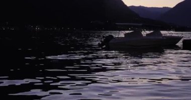 Seaside bay view with boats on Mediterranean coast, rippling water surface with boats, Kotor bay surrounded by mountains