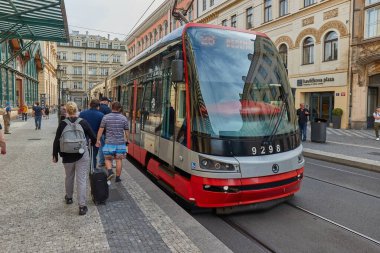 Prague, Czechia - June 1, 2025: Tram arriving at a station, having an important role in Brnos public transport system. People on the street in front of Masarykovo railway station