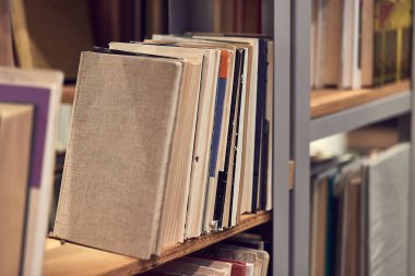 Kütüphanenin raflarında bir sürü kitap var.