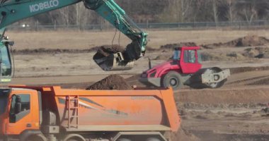 Budapeşte, Macaristan - 10 Şubat 2022: Toprak, güçlü ısı sisi ve toz dolu bir yol inşaatında çöp kamyonu, altyapı geliştirme çalışmaları