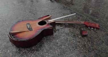 Karlı yağmurda yere düşen kırık bir gitar. Öfke, çalma ve parçalanmış enstrümandan sonra sona erdi.