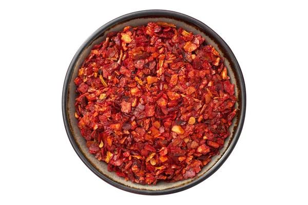 stock image Bowl of dried paprika and hot pepper flakes, isolated on white. Pepper spice and paprika seasoning  closeup. Top view.