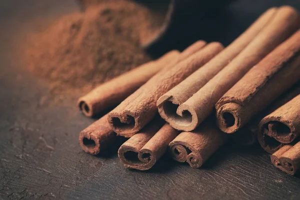 Aromatic Cinnamon Sticks Pile Sprinkled Ground Cinnamon Background Selective Focus — Stock Photo, Image