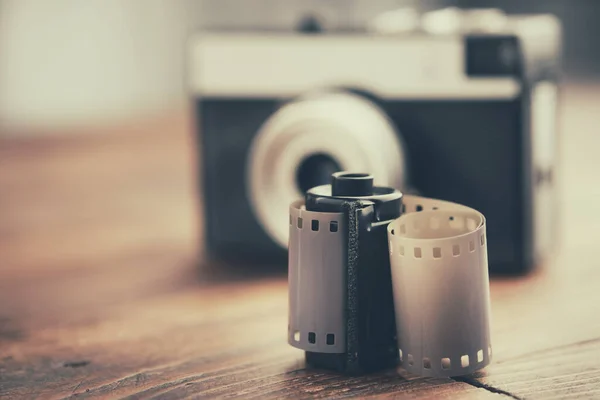 古い写真フィルム ロール カセットと背景にレトロなカメラ — ストック写真
