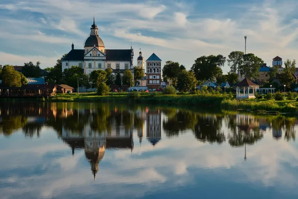 夜の古代コーパス クリスチャン教会 ミンスク地域 ベラルーシ ベラルーシのネスヴェンシュ市の湖に反映された主の体の遠い寺院 — ストック写真